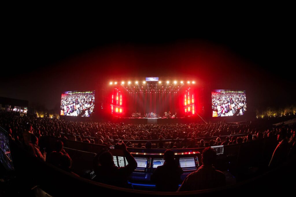 Official Jashn-e-Rekhta photographer capturing the massive crowd and illuminated main stage at night.