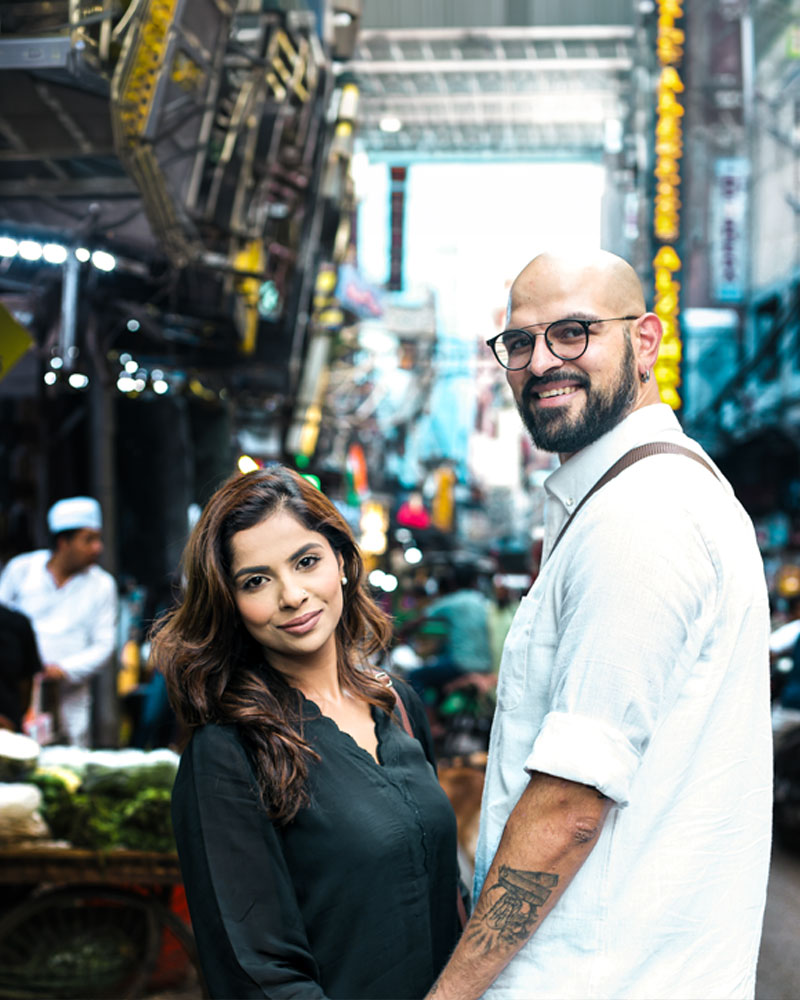 Happy couple smiling during candid pre wedding photography in Chandni Chowk Delhi surrounded by vibrant market streets