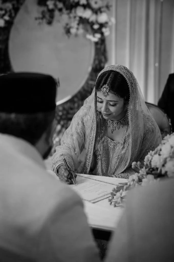 Bride signing nikah papers during Muslim wedding ceremony in Aligarh