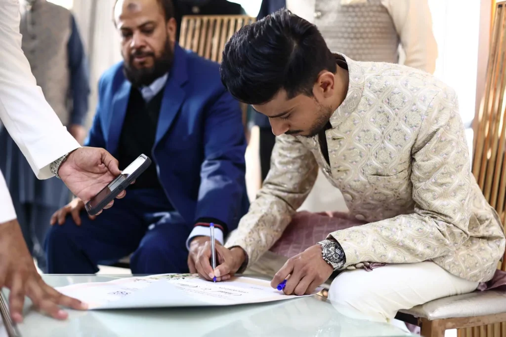 Asim during the nikah ceremony signing process at the wedding in Noida