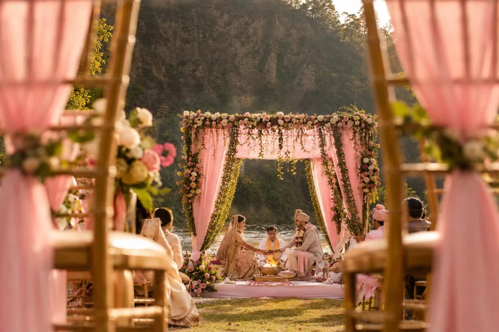 Destination wedding ceremony setup by the riverside with floral mandap and jungle backdrop at Taj Corbett