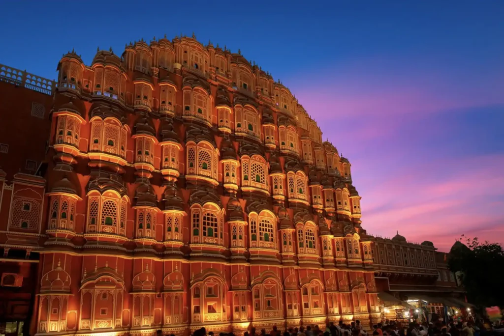 Destination wedding photography in Jaipur featuring an Indian couple at the iconic Hawa Mahal.