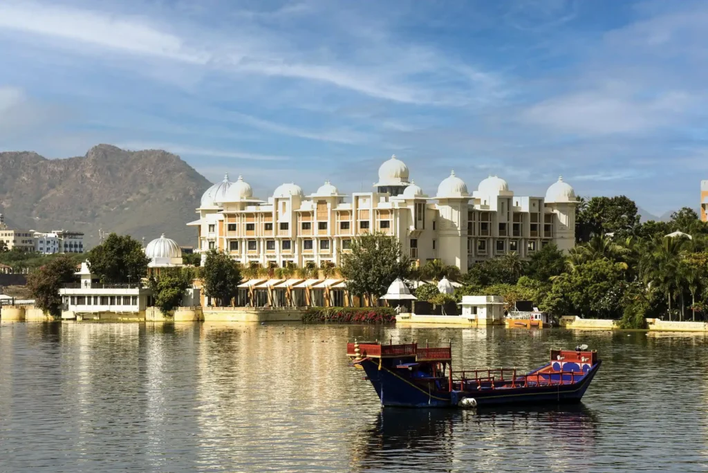 Destination wedding photography at Udaipur featuring an Indian couple against the iconic Lake Pichola and City Palace.