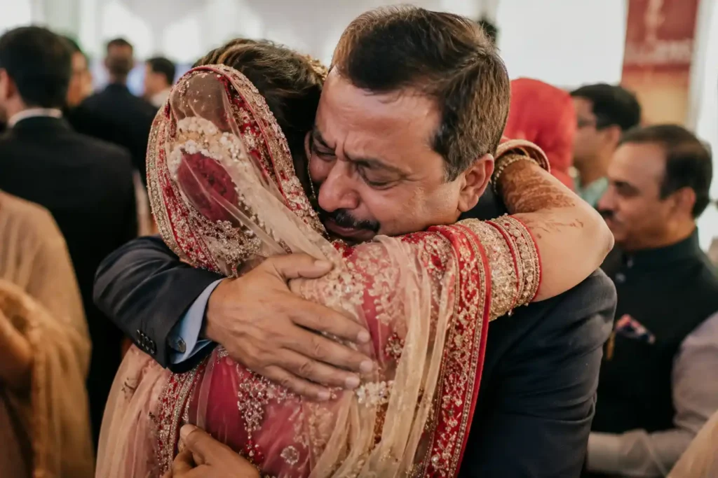 Father embracing his daughter during an emotional moment at an Indian wedding