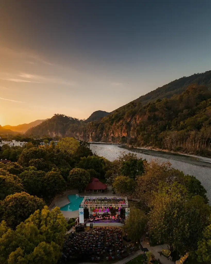 Audience attending Ragas by the River cultural music festival beside a riverside stage at sunset, documented by Photosynthesis Photography Services