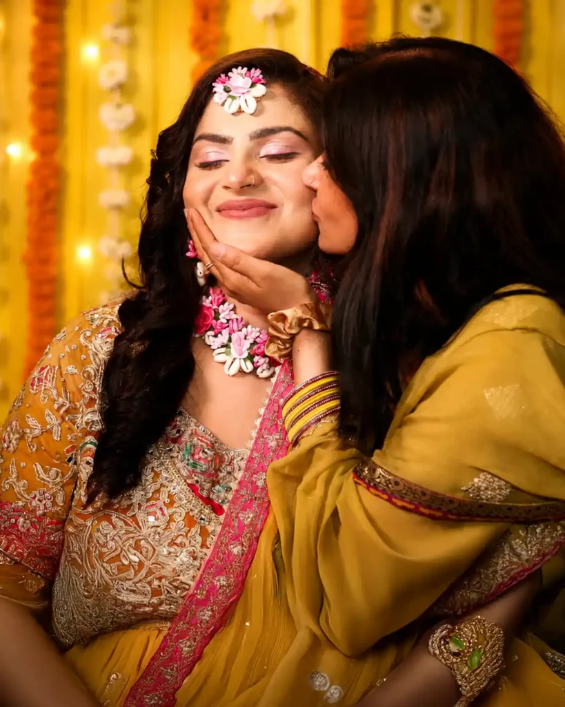 Zobia smiles as a family member kisses her cheek during the Haldi celebrations at Fort Royale, Aligarh.